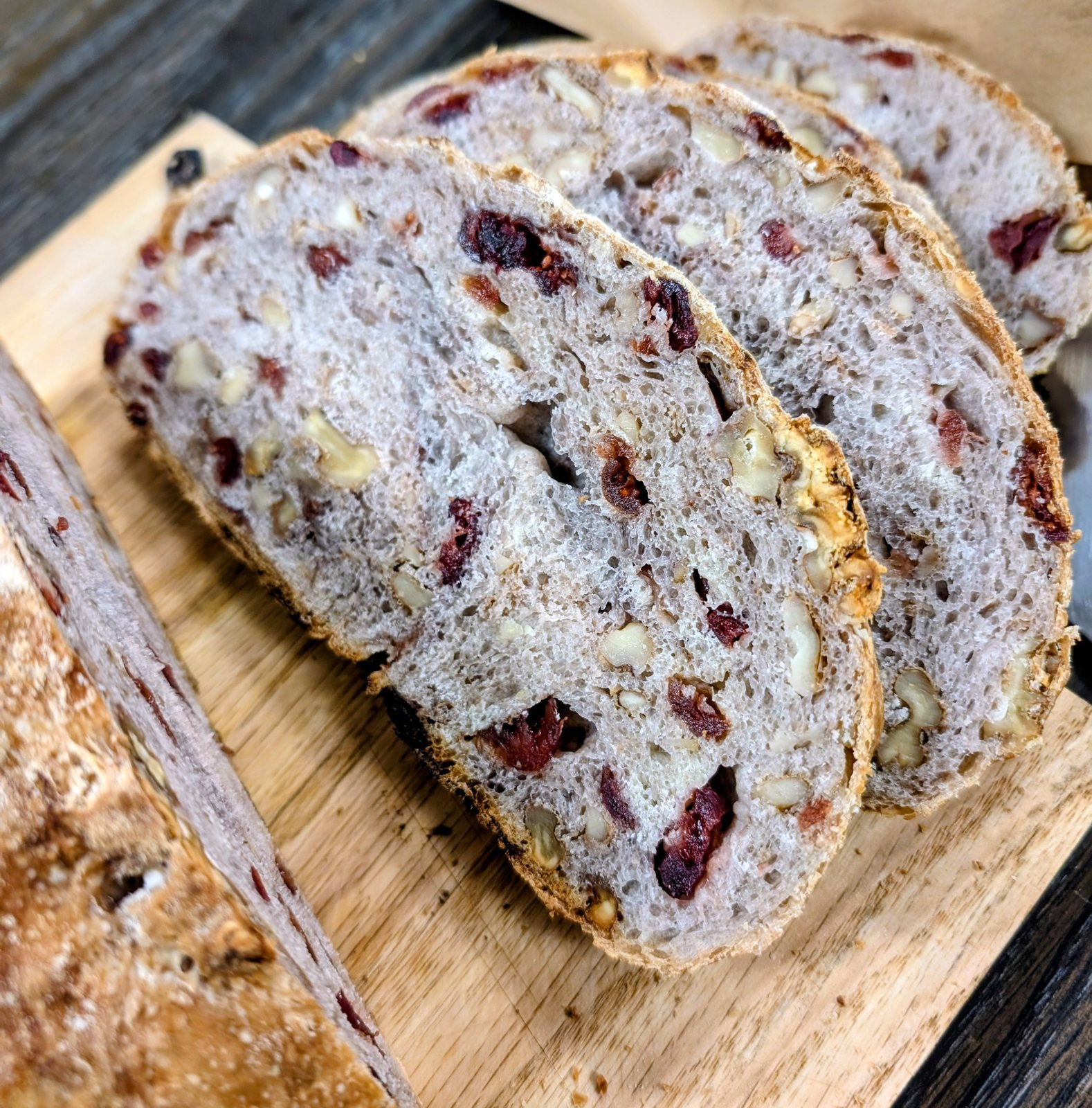 Cranberry and nut bread sliced on a wooden board